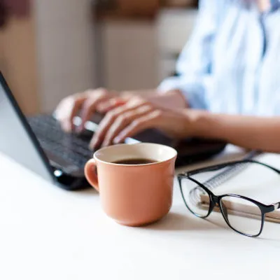 Remote working from home. Freelancer workplace in kitchen with laptop, cup of coffee